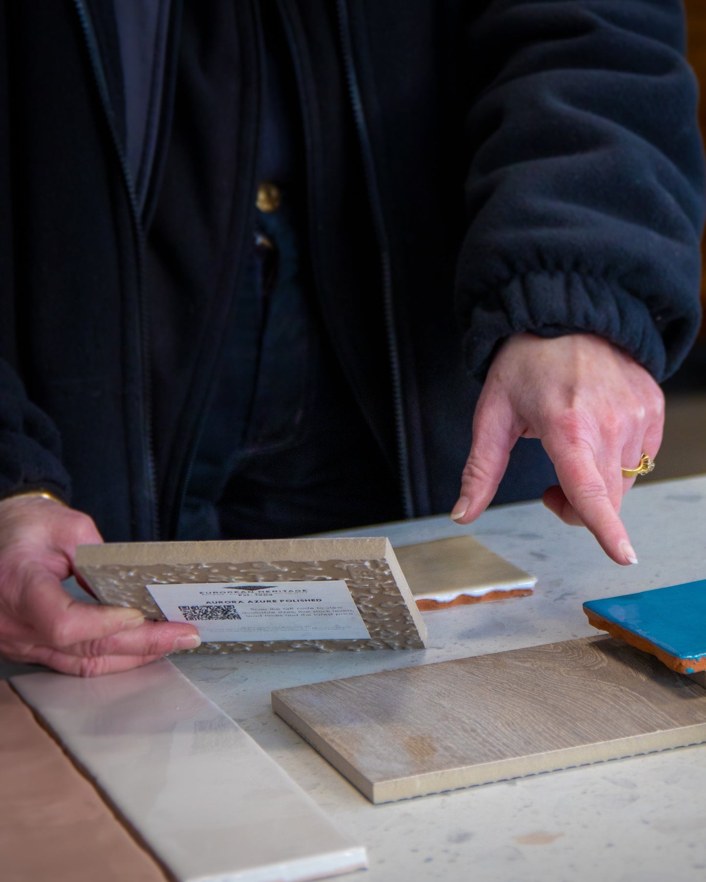 Our founder examining samples of tiles giving advice to a customer
