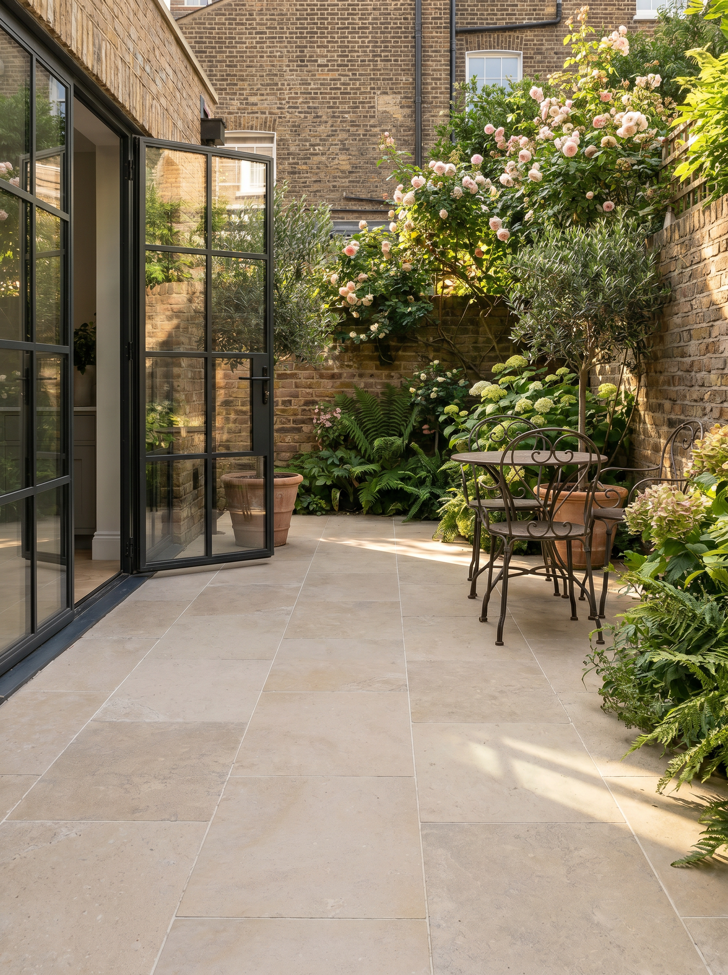 Outdoor patio area with a glass door leading to a garden.