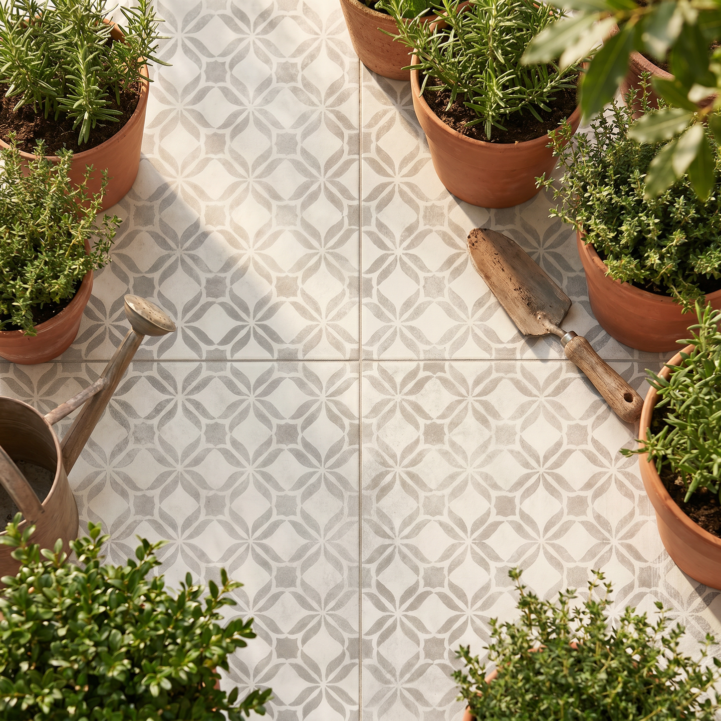 Patterned tiles with potted plants and gardening tools on a patio