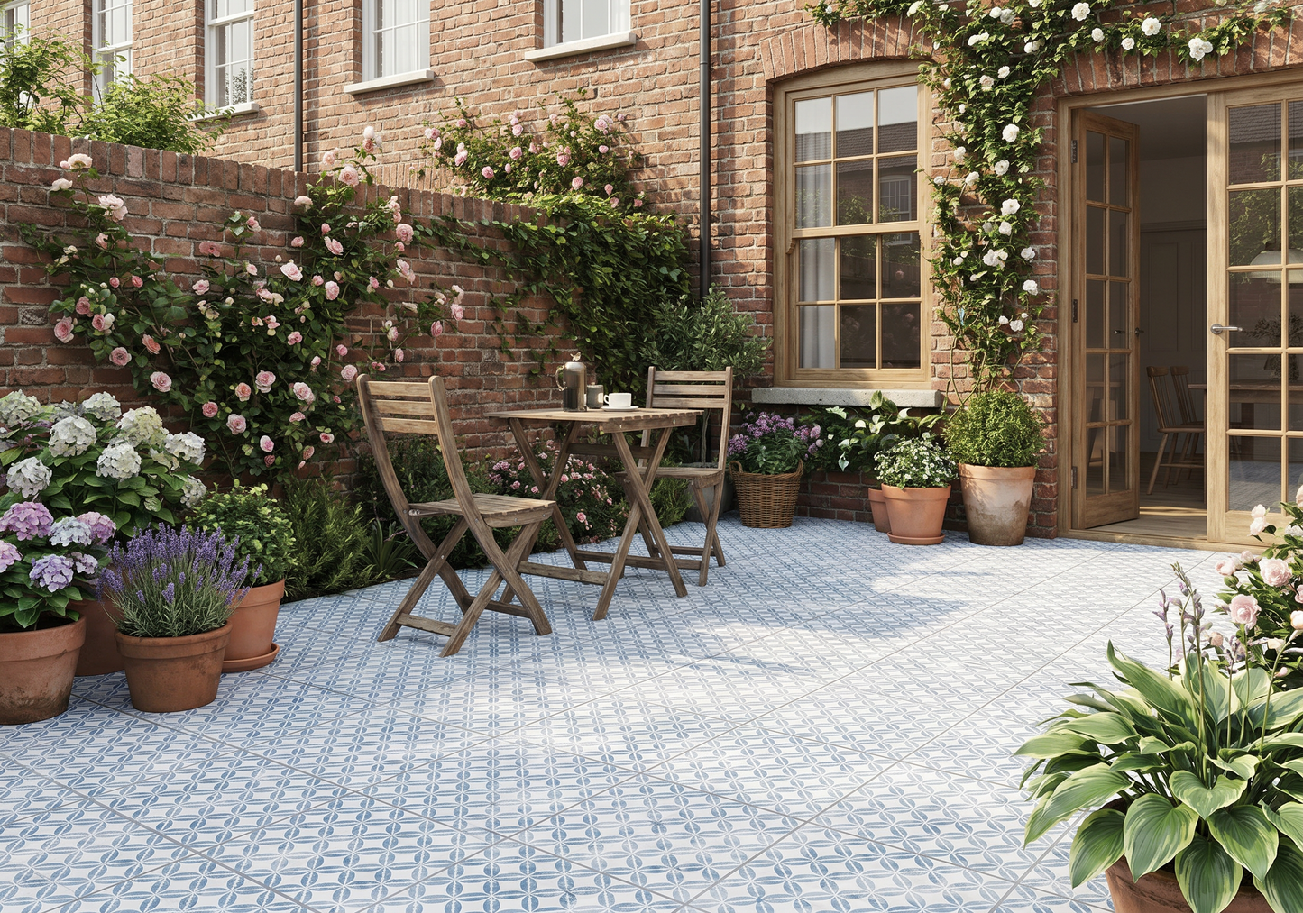 Outdoor patio area with a brick building, table, chairs, and potted plants.