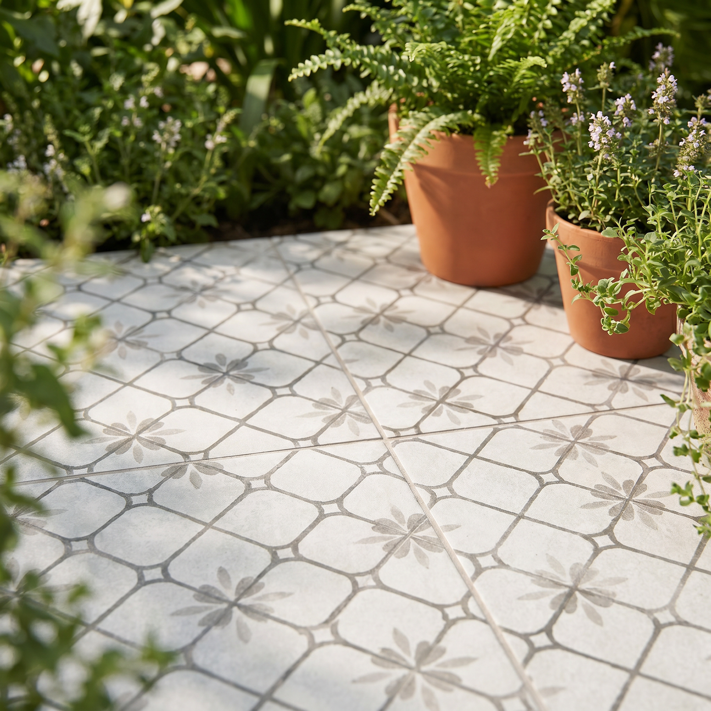 Patterned patio with potted plants in a garden setting